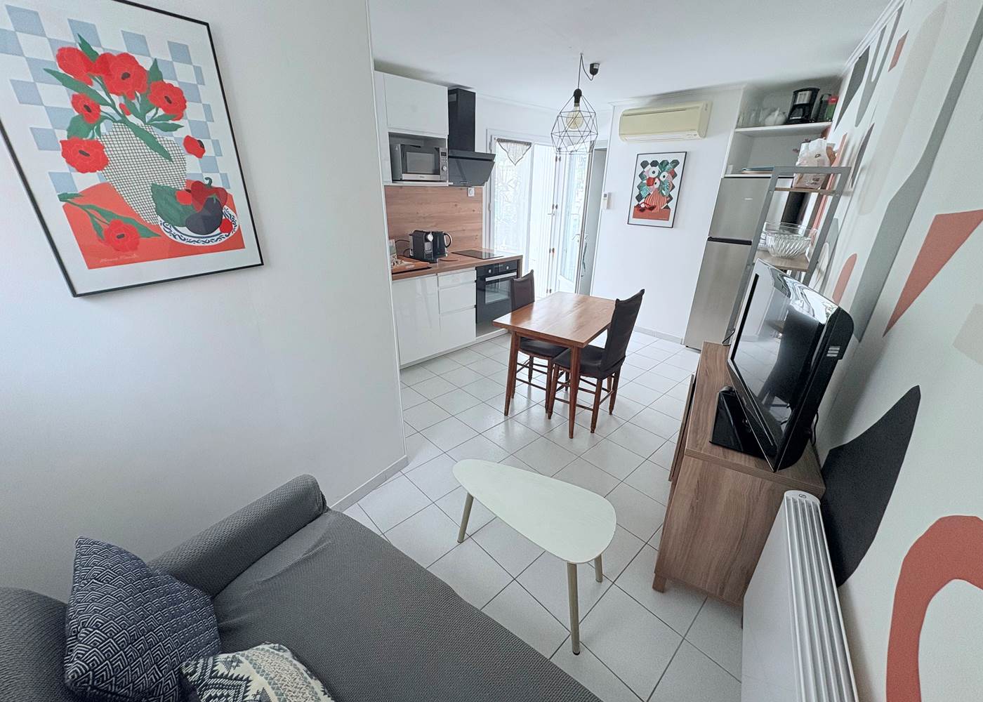 Maison Réthaise 2 – Séjour cosy et graphique Ambiance contemporaine dans un espace bien agencé, parfait pour savourer des moments de détente en centre-ville.