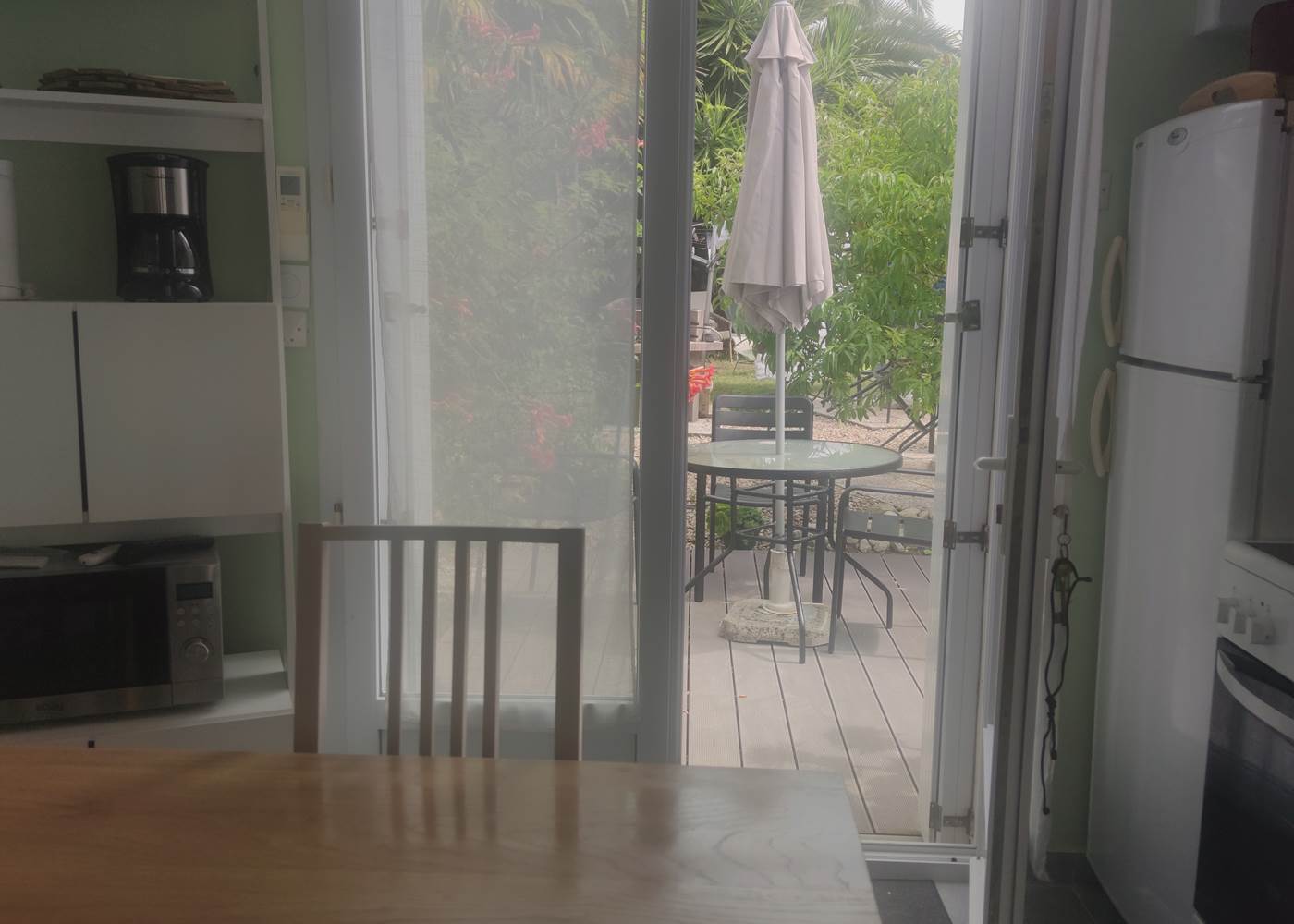 Table avec vue sur la terrasse Une transition naturelle entre l’intérieur et l’extérieur pour savourer chaque instant dans un cadre serein.