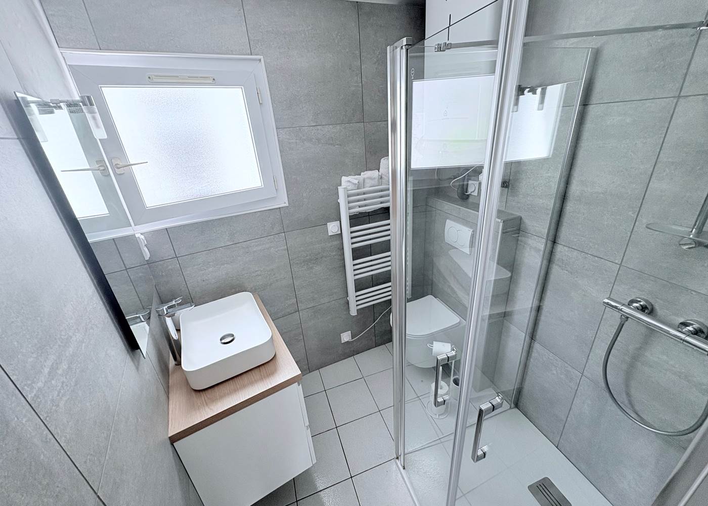 Maison Réthaise 2 – Salle d’eau lumineuse Espace soigné avec équipements modernes et rangements, pensé pour votre bien-être au cœur du centre-village.