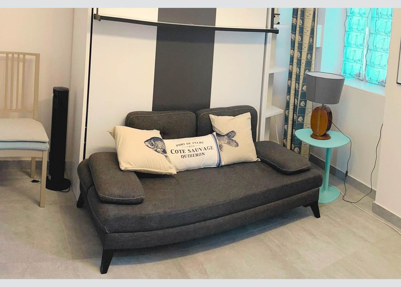 Studio – Coin salon avec charme rétais Ambiance chaleureuse et touche marine dans cet espace modulable en plein centre piéton. Confort assuré pour un séjour paisible à La Flotte