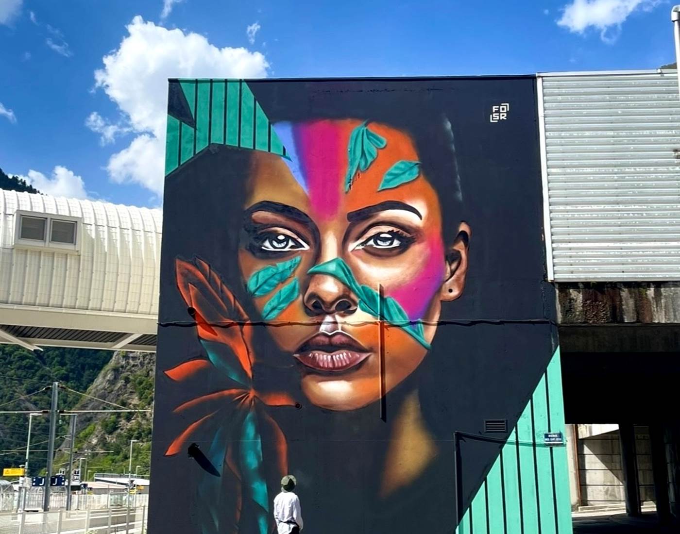 Le street artiste FOSR devant une de ses oeuvres