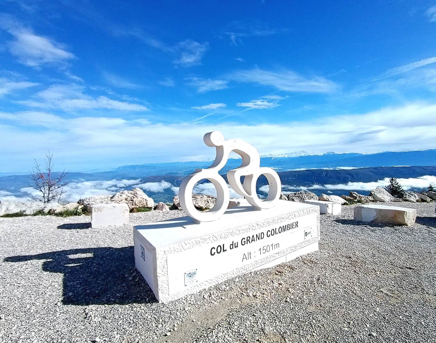 Une statue de cycliste au sommet du Grand Colombier, avec la chaîne du Mont Blanc en arrière-plan. Epreuve réputée du Tour de France à 1h de Genève et Annecy.