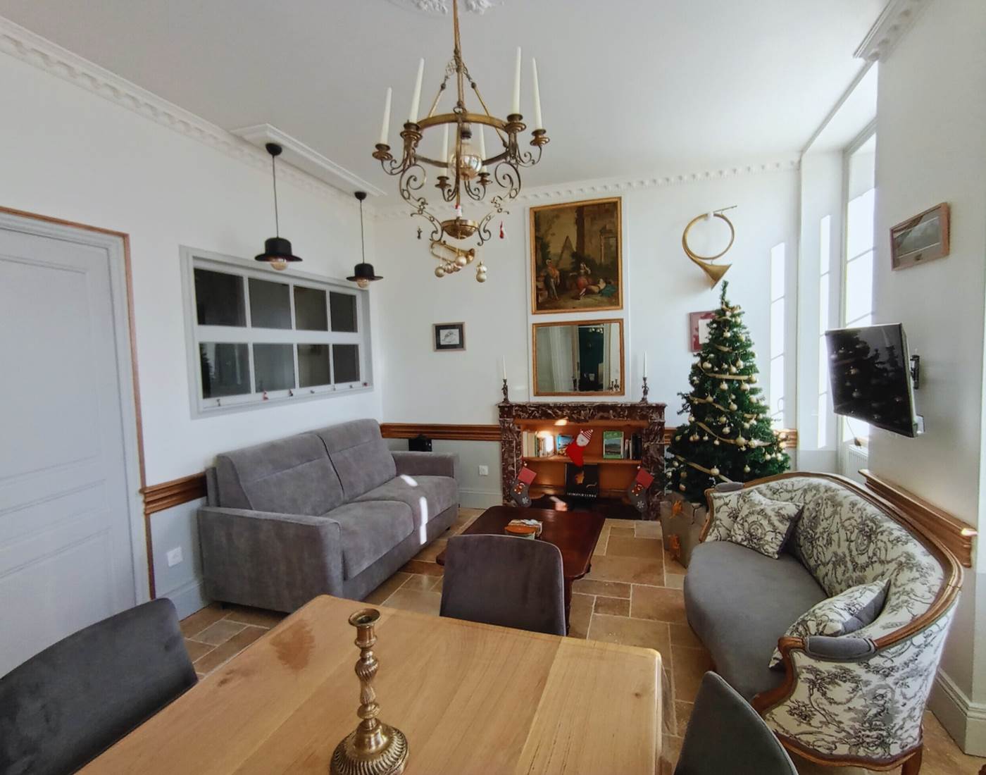 Intérieur chaleureux du Manoir du Colombier, maison de famille authentique et demeure historique typiquement française décorée pour Noël.