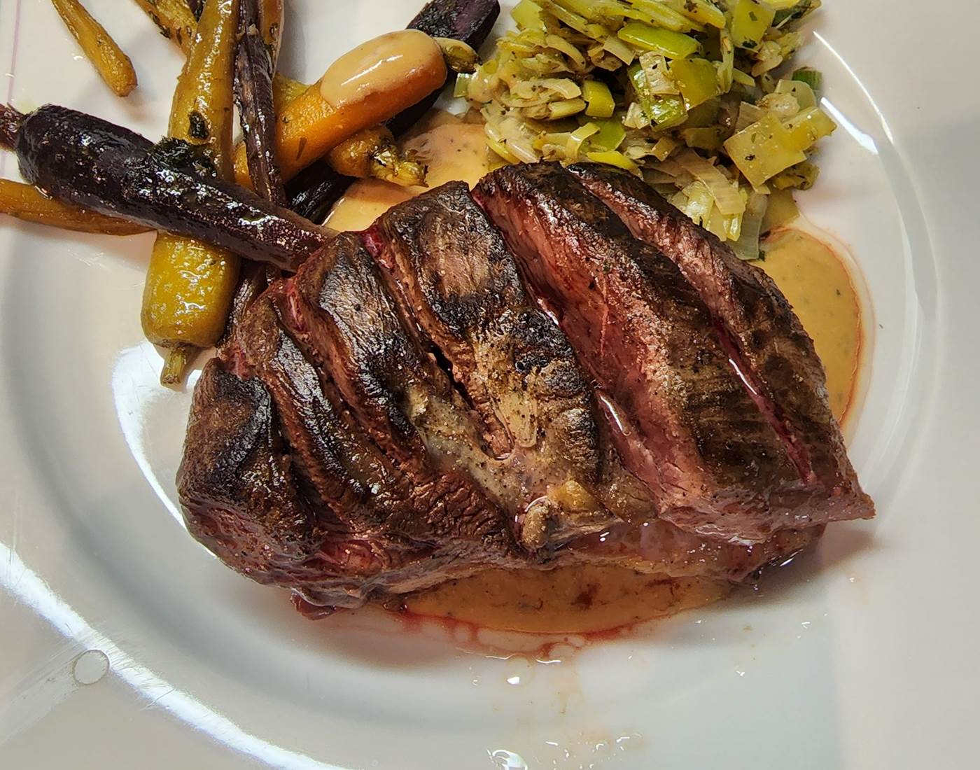 Fondue de poireaux aux herbes de Provence, mini carottes tricolores en persillade et un demi-magret de canard avec une sauce au fond de veau – Le Veilleur de Noblat