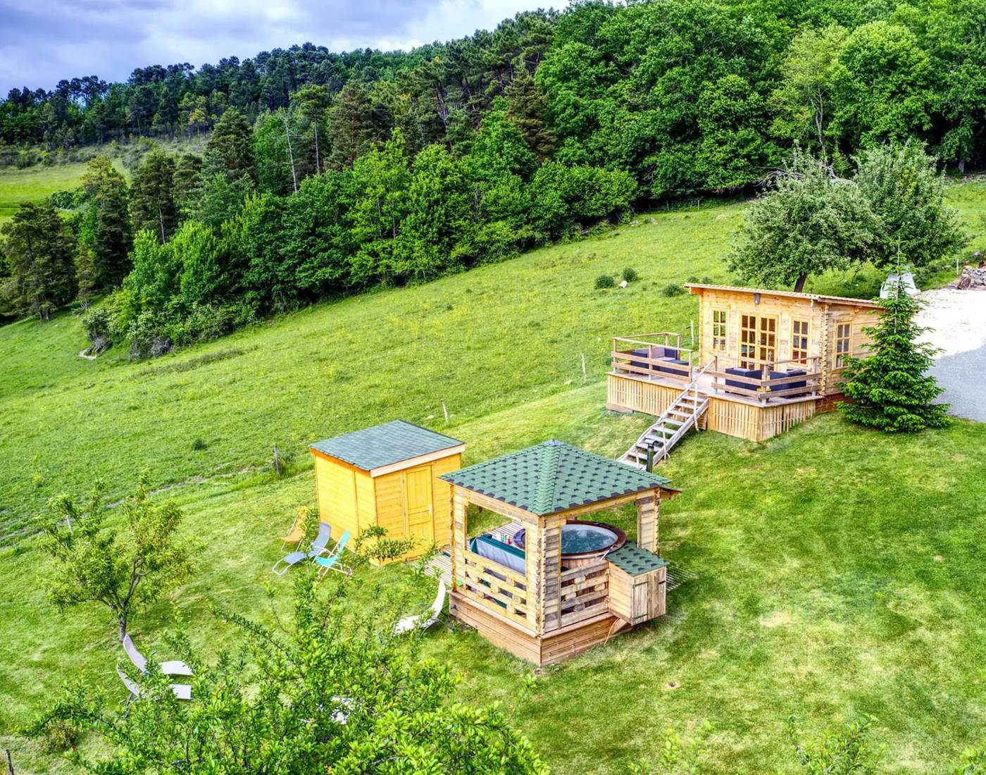 Espace balnéo composé d'un bain extérieur à bulles et jets hydromassants 6/8 pers, d'un sana infrarouge 6/8 pers. et d'un chalet cocooning