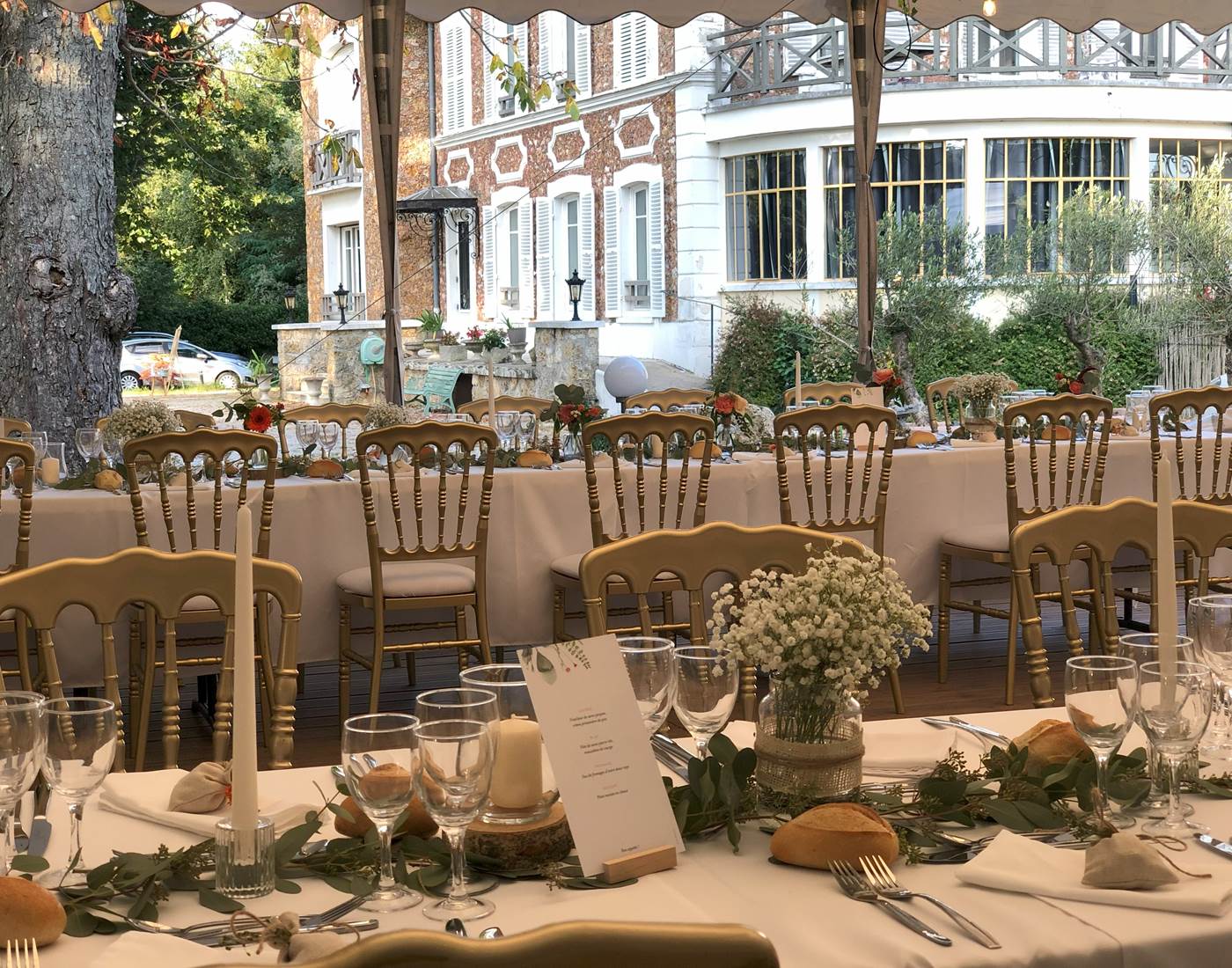 Repas de mariage de mariage sur la terrasse en bois couverte d'un chapiteau