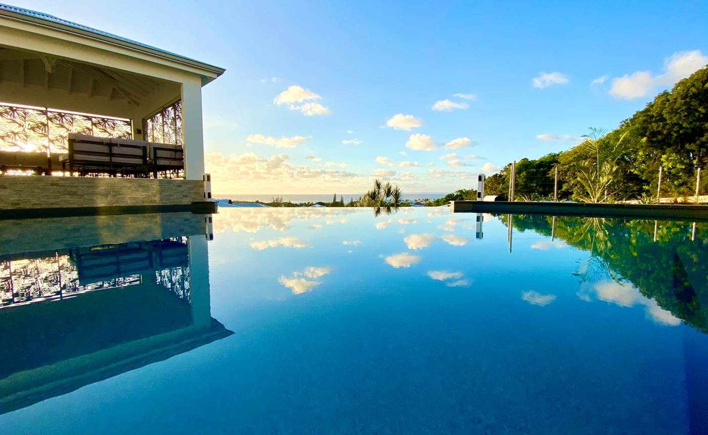 Piscine à débordement vue mer avec coin salon sous le carbet