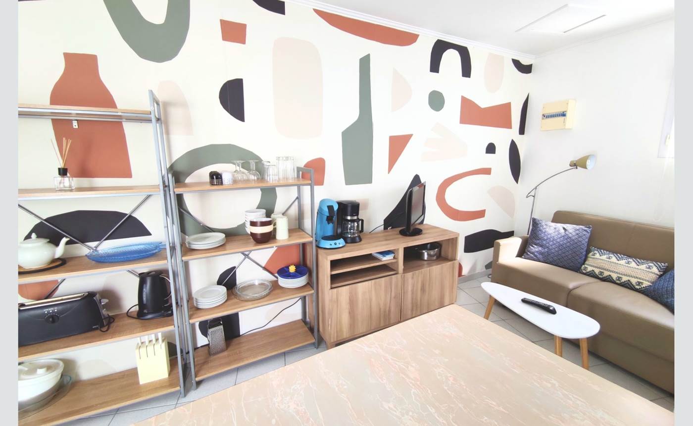 Maison Réthaise 2 – Séjour cosy et graphique Ambiance contemporaine dans un espace bien agencé, parfait pour savourer des moments de détente en centre-ville.