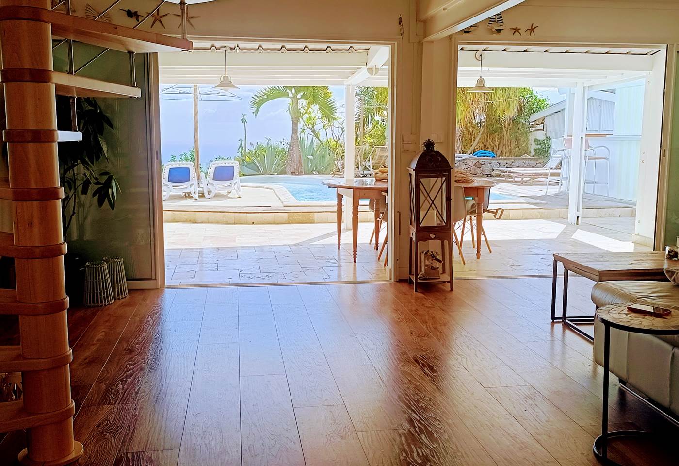 Living-room équipée de grande baie vitrée donnant vers la terrasse de la piscine