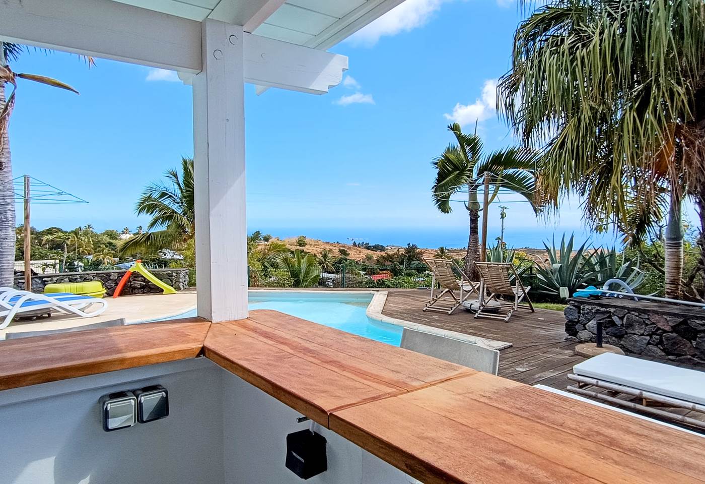 Espace bar donnant sur la piscine et la vue dégagée vers la Mer