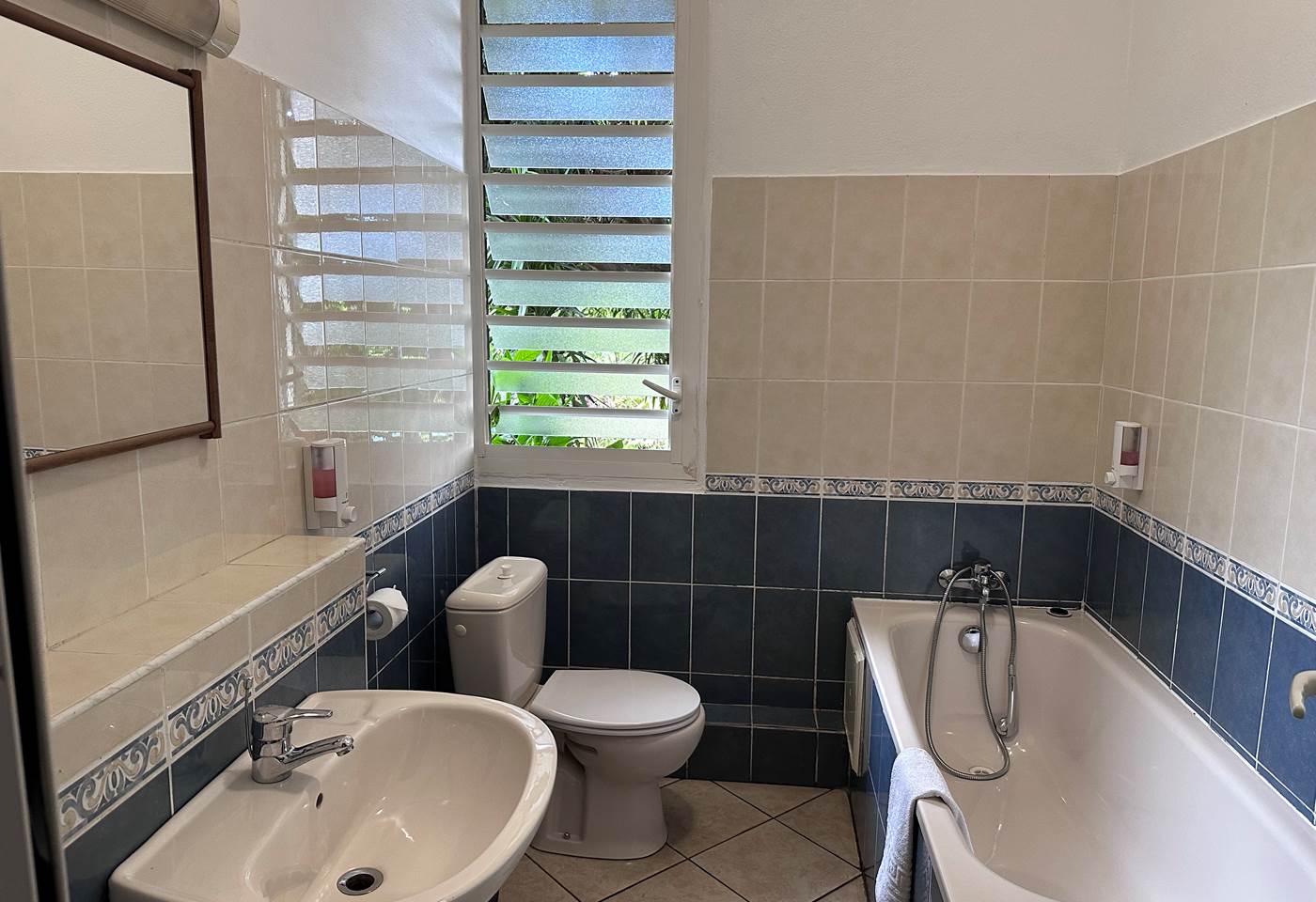 salle de bain privée avec baignoire, toilette et lavabo