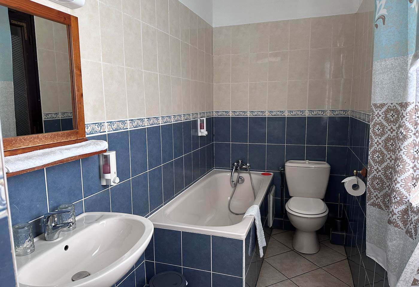 salle de bain privée avec baignoire, toilette et lavabo