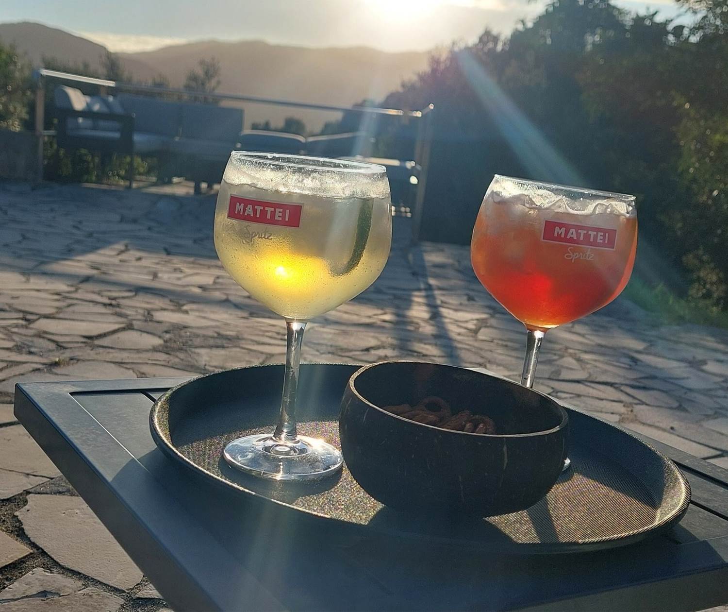 Moment de détente au Domaine Cardu avec deux Capo Spritz au Cap Mattei face au coucher du soleil sur les montagnes corses.