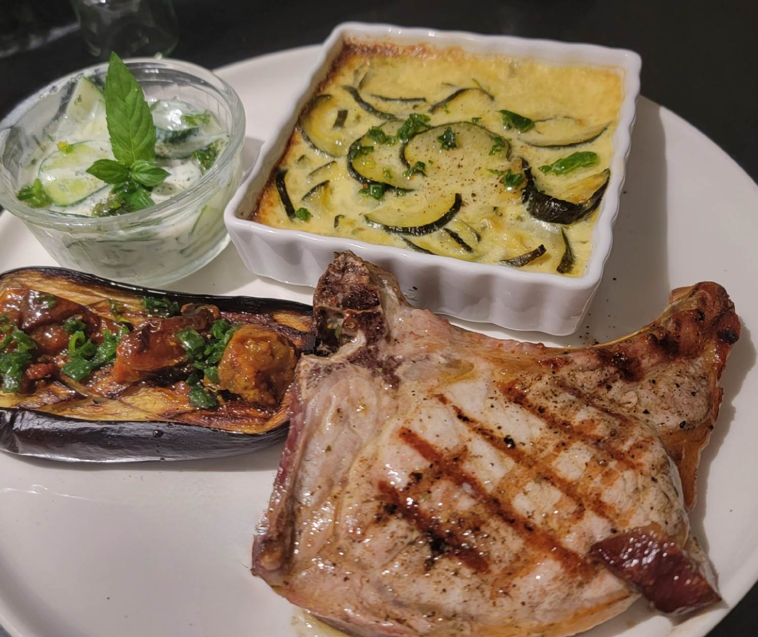 Côte de porc grillée accompagnée d'un gratin de courgettes à la tome de brebis corse, aubergine et tomates cerises confites au Domaine Cardu.