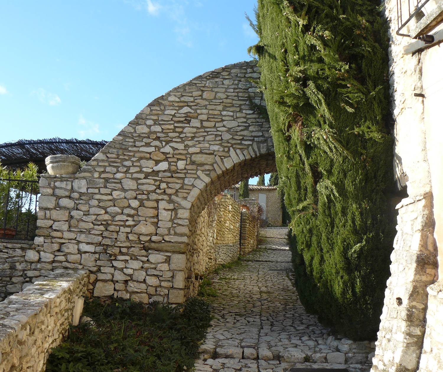 Belle arche en pierres blondes du Luberon dans le village de Joucas