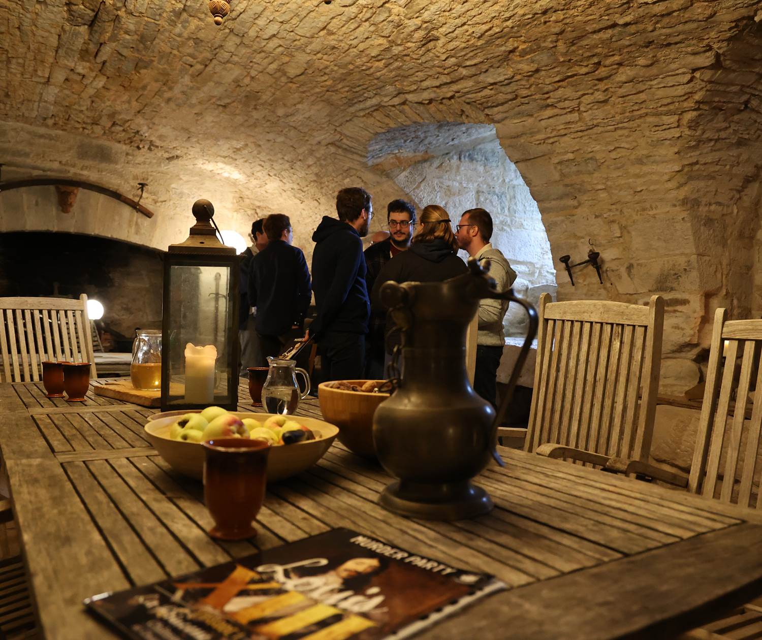 Retrouvaille entre amis dans la salle voutée pour jouer la murder party Louis XIII au Château de Saint-Chamarand