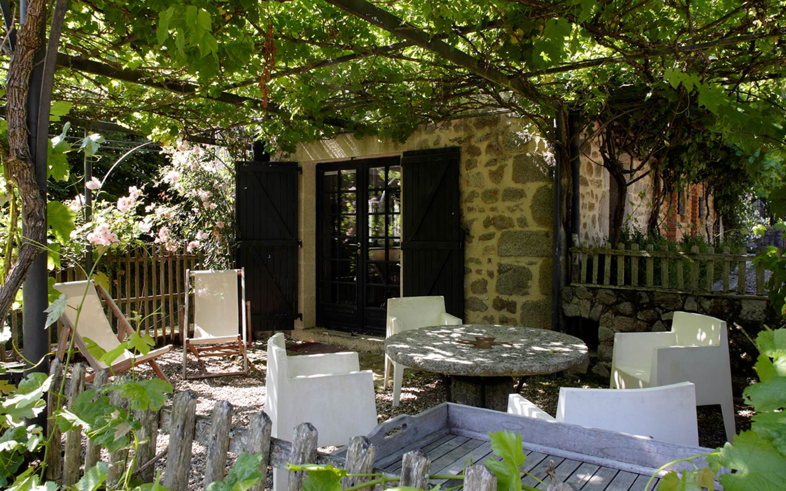 La terrasse privée de la Pichonna avec sa pergola recouverte de roses