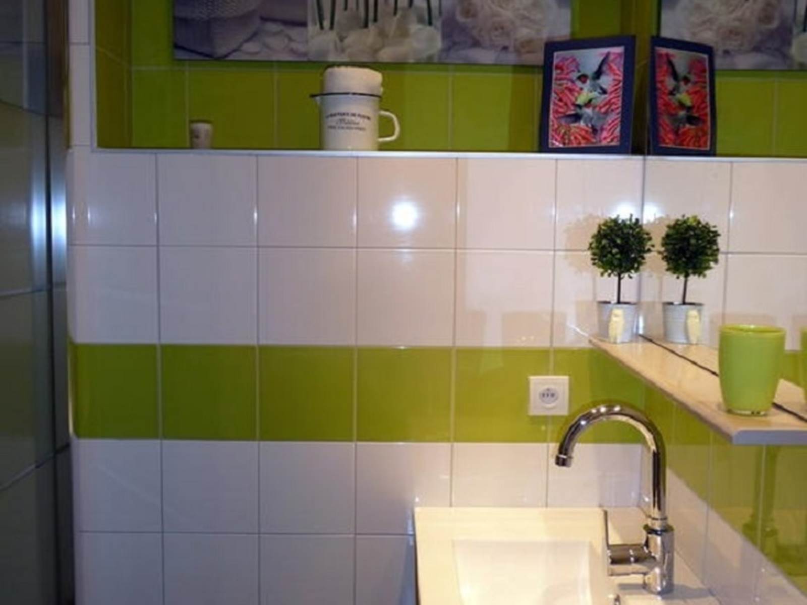 Salle d'eau avec cabine de douches, vasque, sèche serviettes, sèche cheveux, articles de toilette.