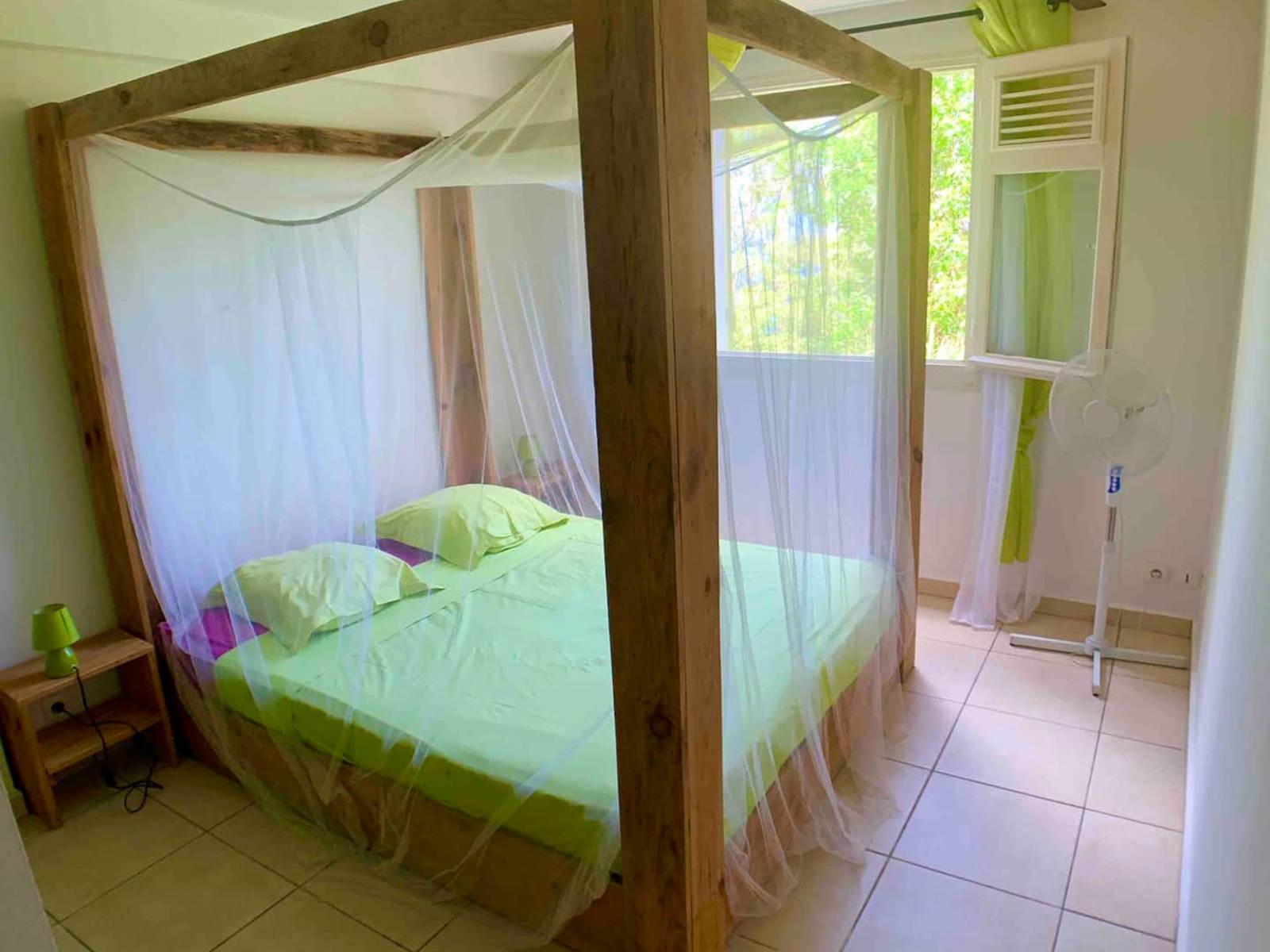 Chambre ventilée avec lit à baldaquin et moustiquaire