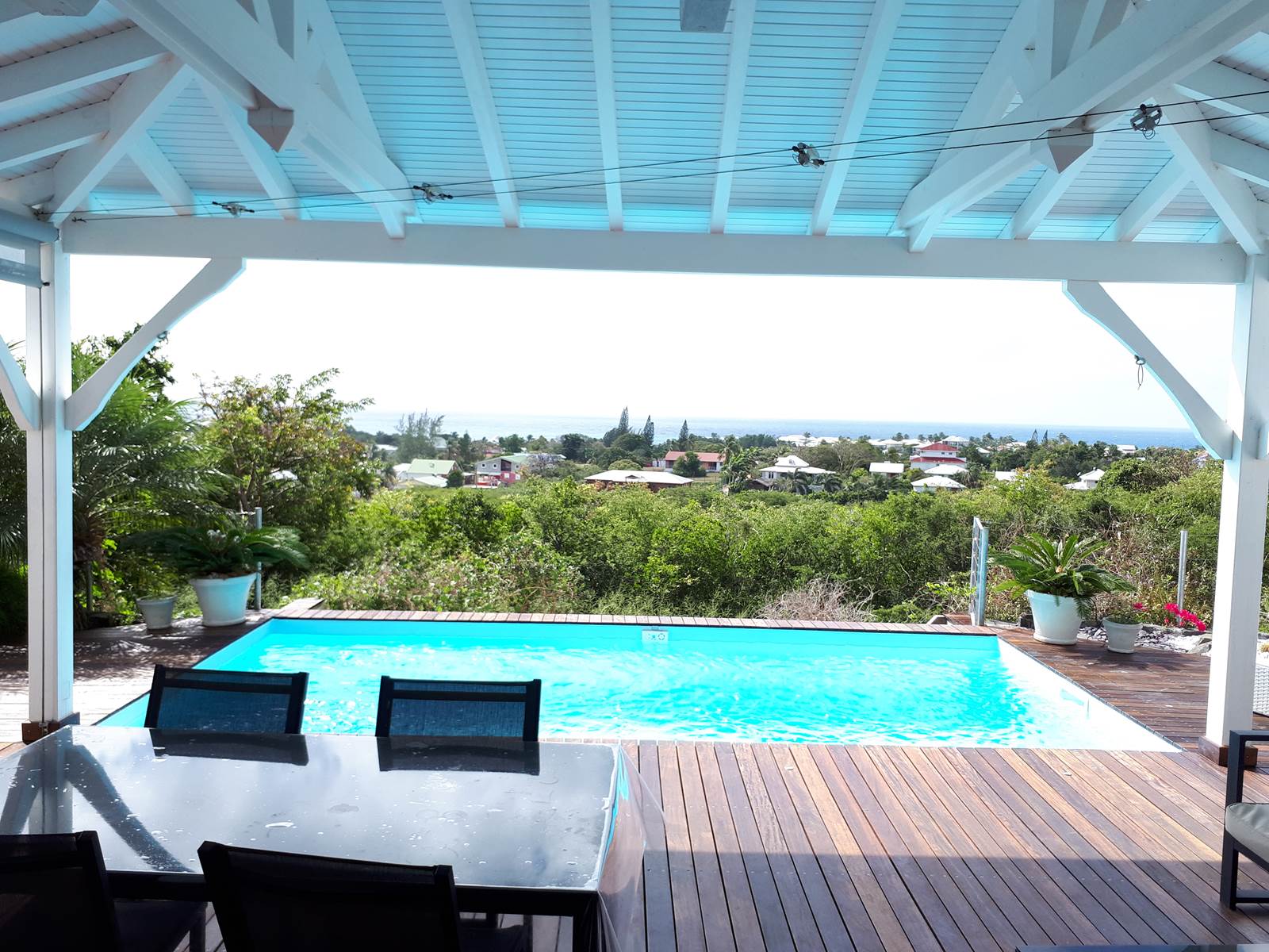 Terrasse couverte ouverte sur la piscine vue mer