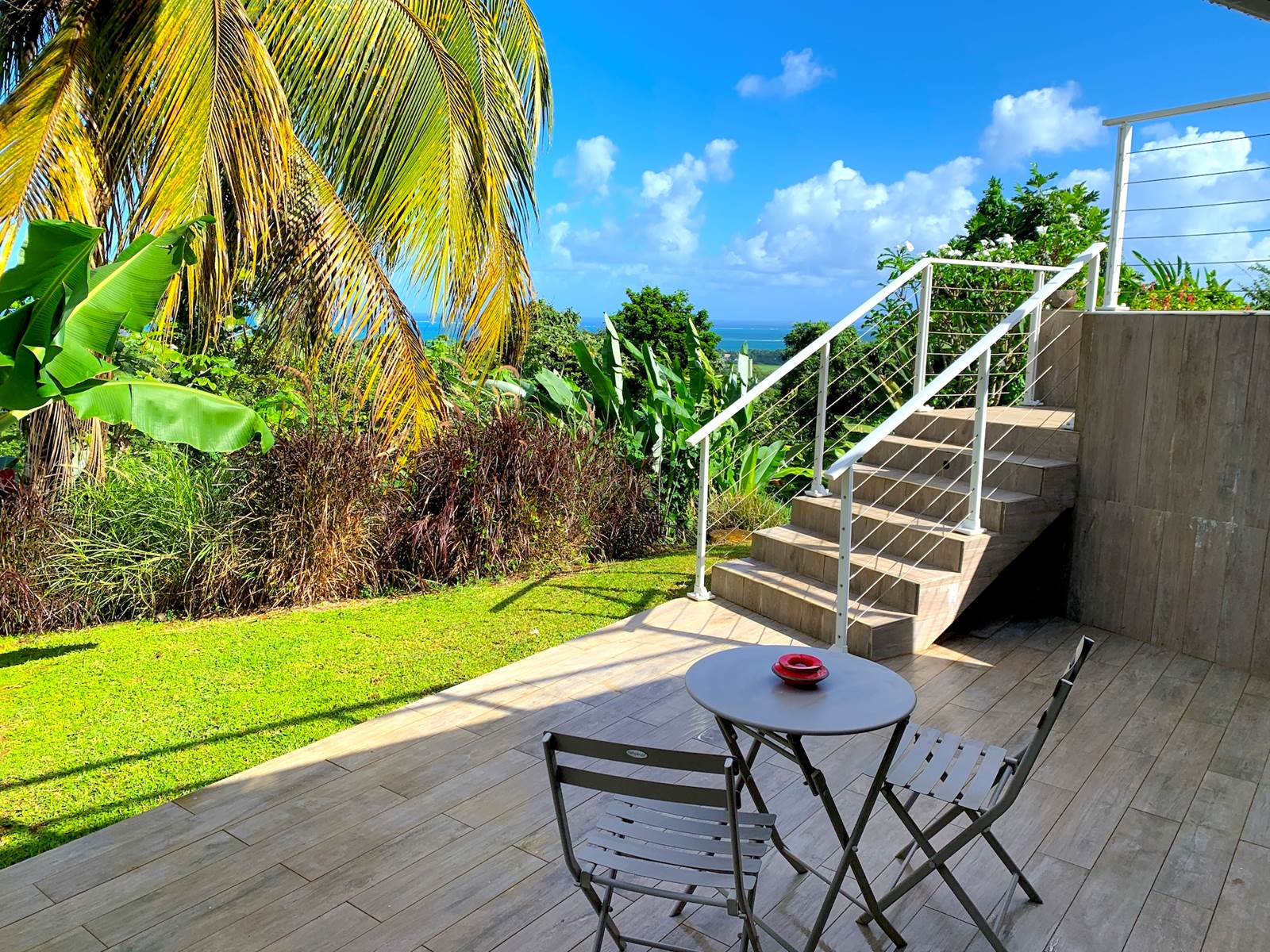 Terrasse privative avec vue mer et accès piscine par escalier