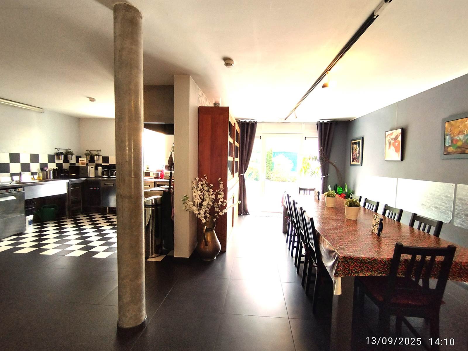 La grande table conviviale est juste à côté de la cuisine tout inox