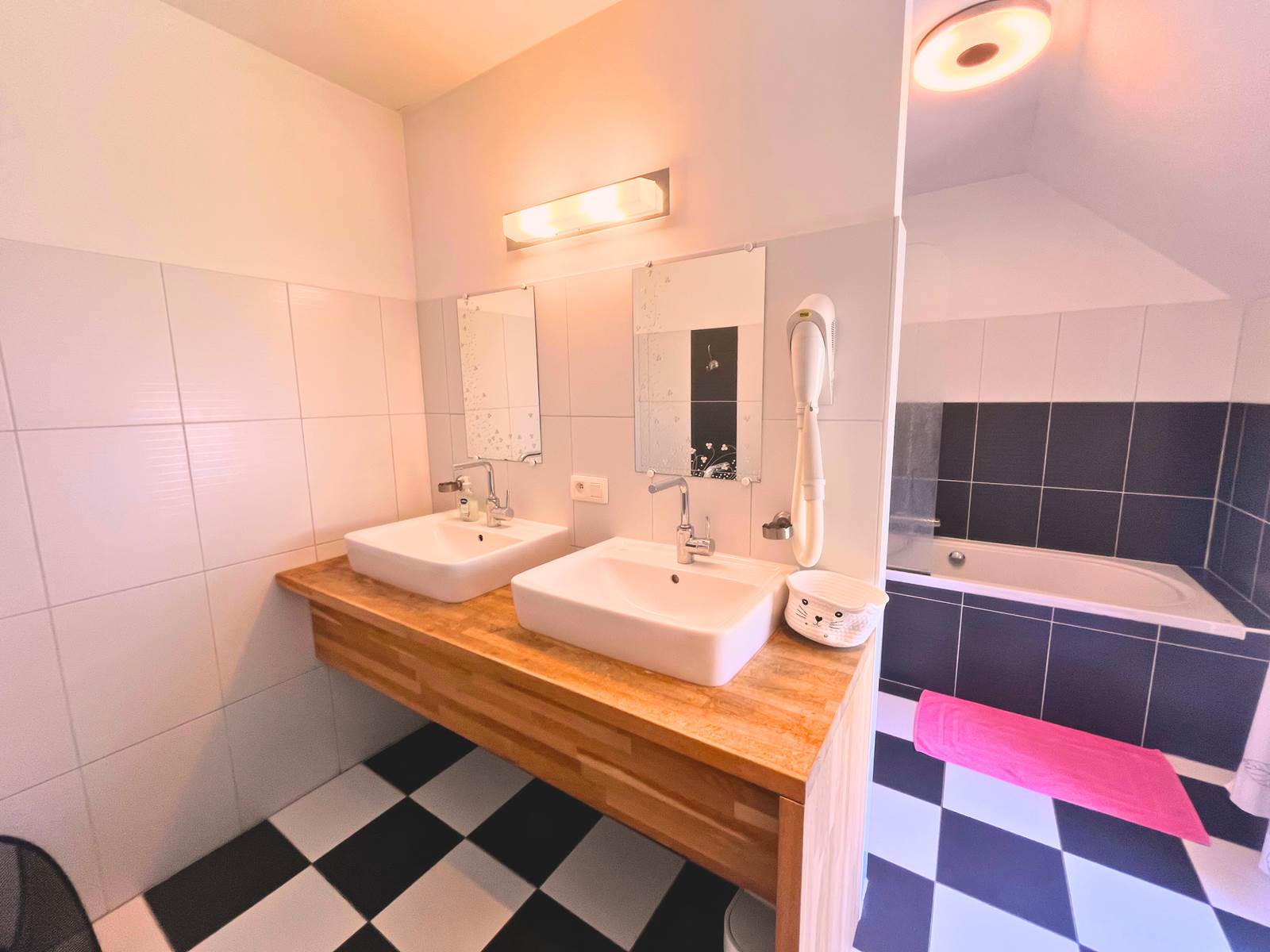 La salle de bain, baignoire, double lavabo et wc de la chambre Fuschia