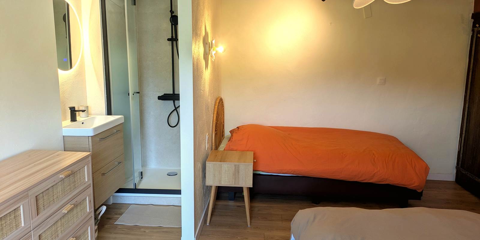 Modern walk-in shower and sink area in family suite for three guests