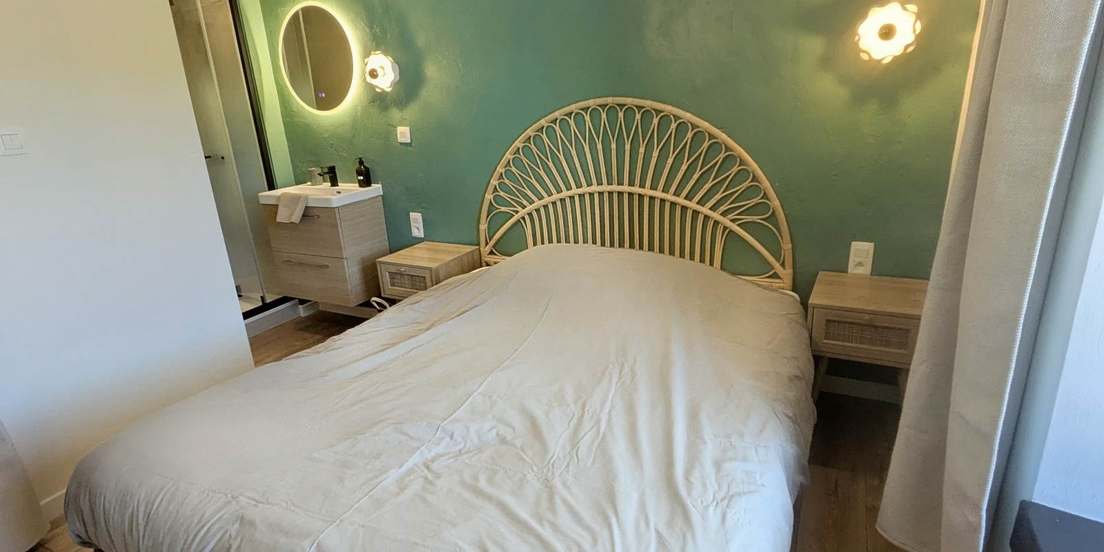 alt="Chambre élégante avec lit queen size et salle de douche privative dans le gîte familial en Ardenne belge"