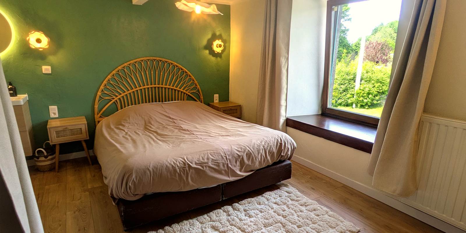 Bright queen size bedroom with large windows in countryside holiday home