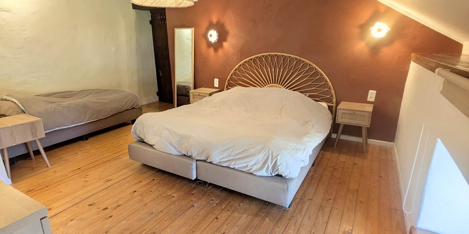 alt="Chambre familiale avec lit king size, lit simple et salle de douche privative dans le gîte grande capacité"