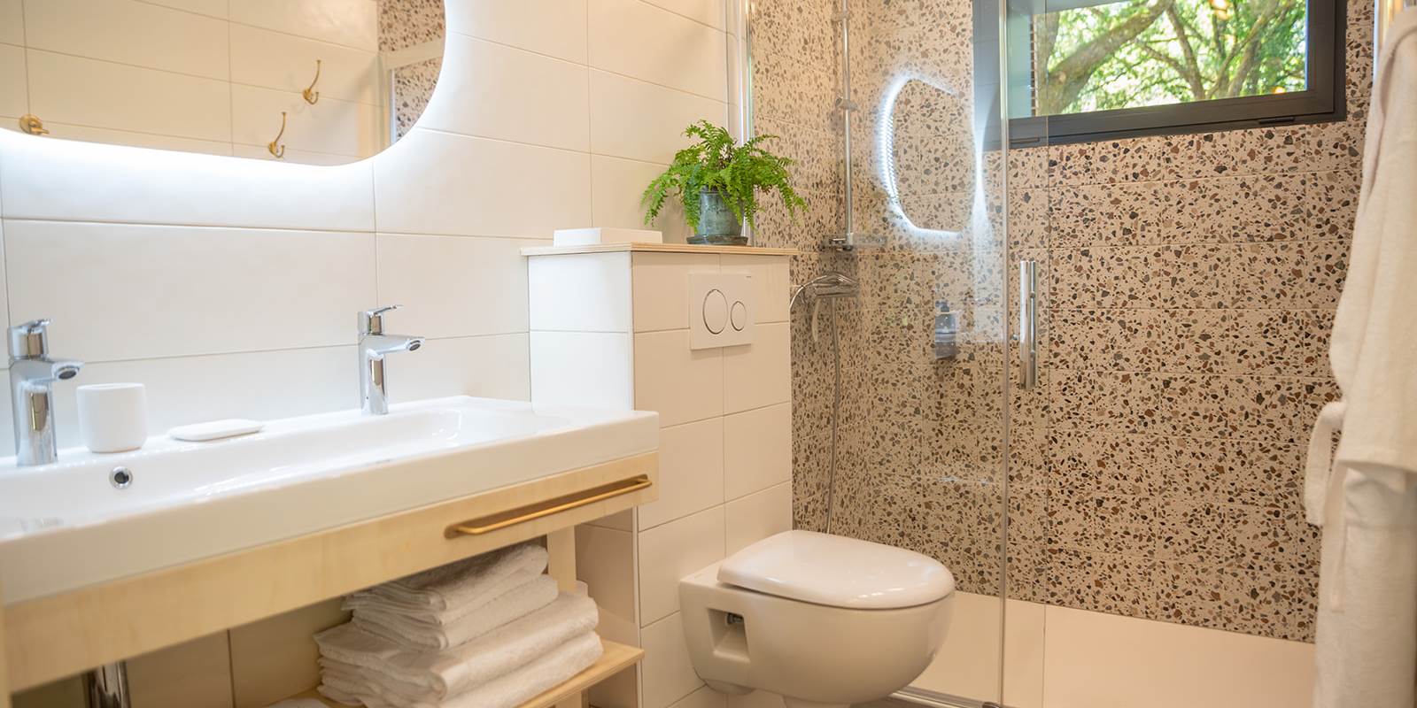 Salle de bain spacieuse avec double vasque, douche et WC