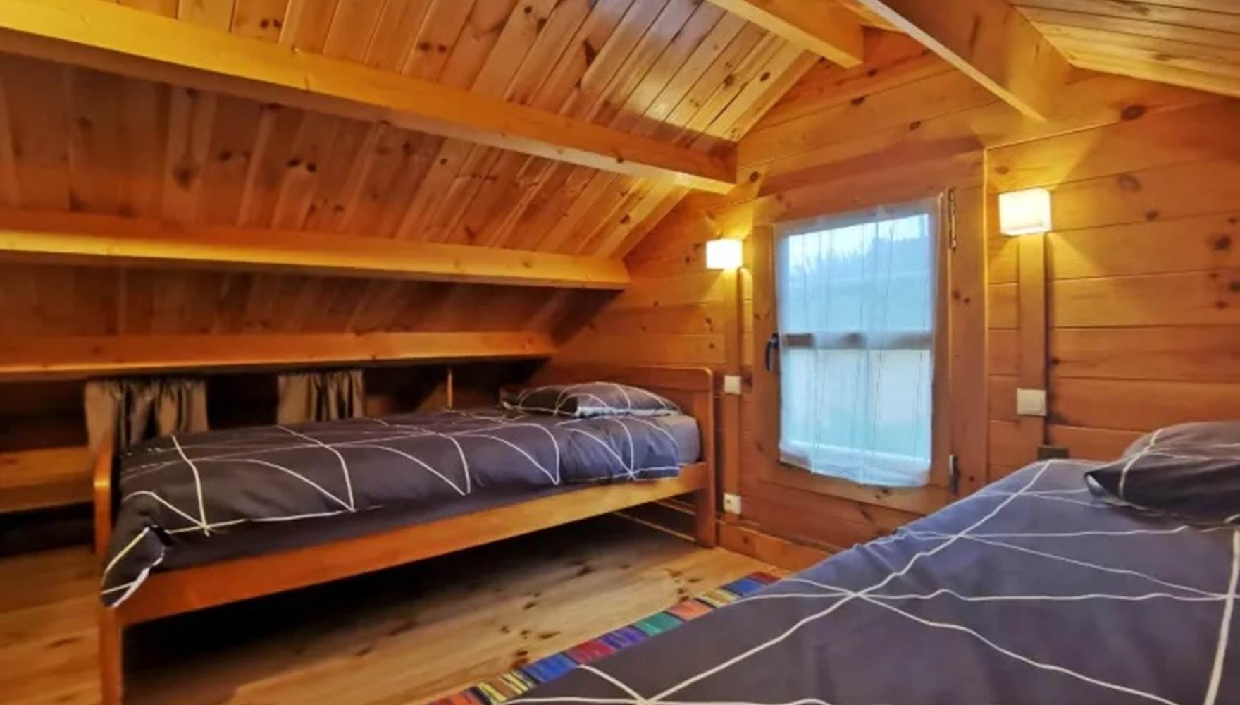 Chambre mansardée avec deux lits simples, parfaite pour accueillir parents et enfants aux Chalets de Kerescar à Plouarzel