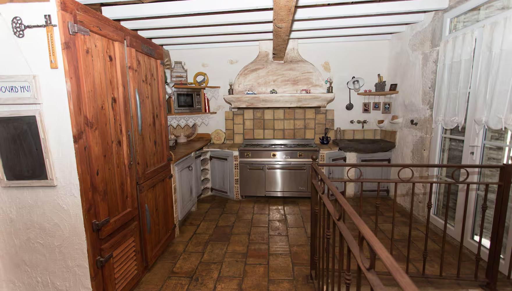 Cuisine moderne avec gazinière, four professionnel, lave-vaisselle et machine à laver