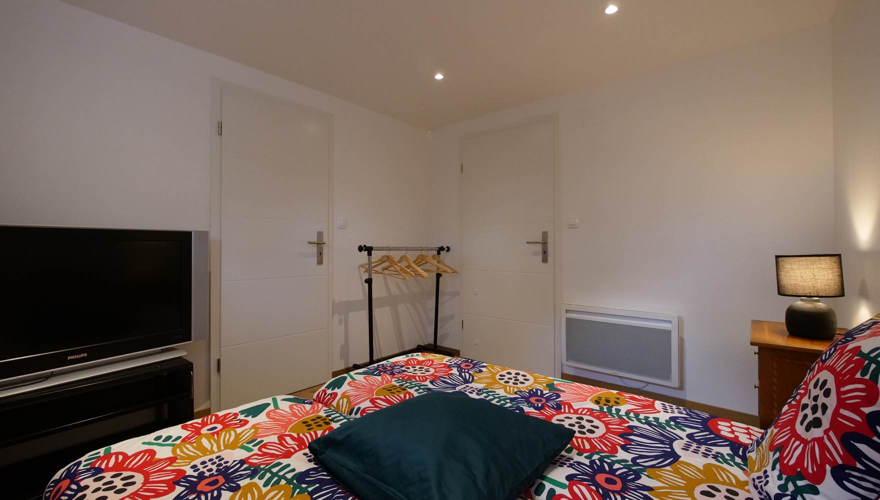 Petite chambre avec porte vers la salle de bain et porte vers le couloir