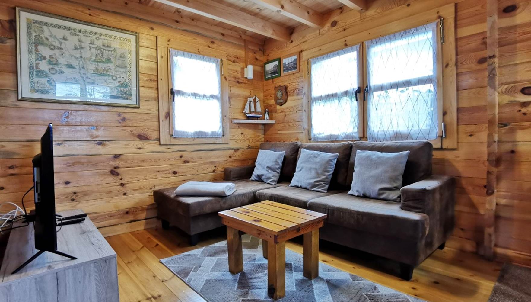 Salon chaleureux en bois avec canapé méridienne, idéal pour un séjour reposant aux Chalets de Kerescar à Plouarzel