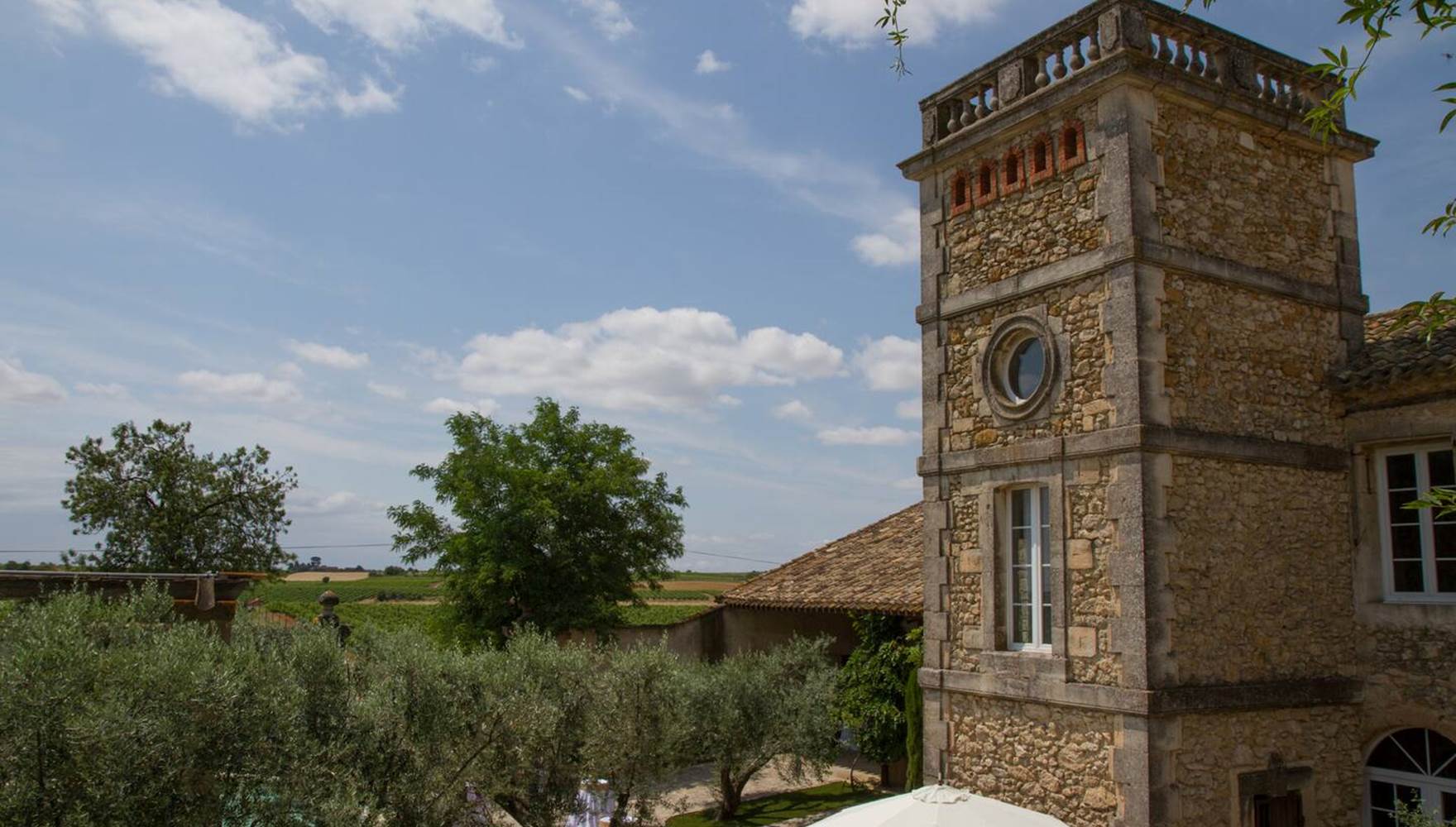 Espace extérieur ombragé avec mobilier de jardin sous des oliviers centenaires