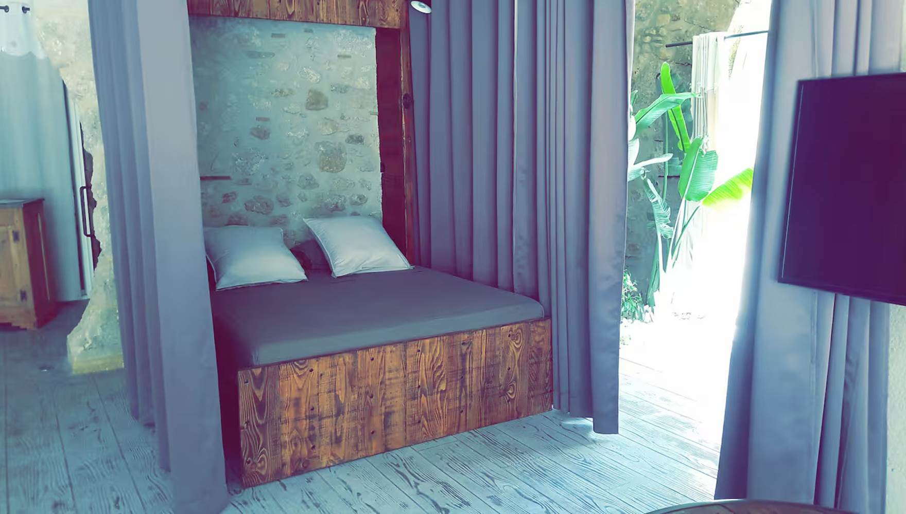 Chambre cosy avec lit 160x200 séparée par un rideau occultant, dans un gîte moderne