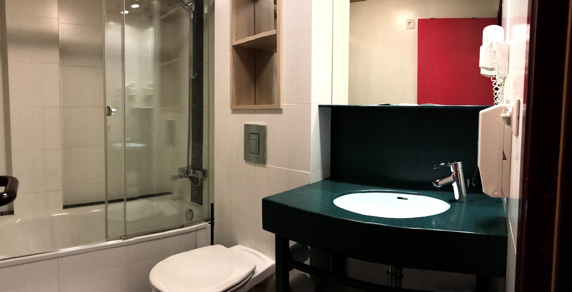 Salle de bain privative de la chambre Twin 13 comprenant une belle douche, un lavabo, un sèche cheveux et toilettes