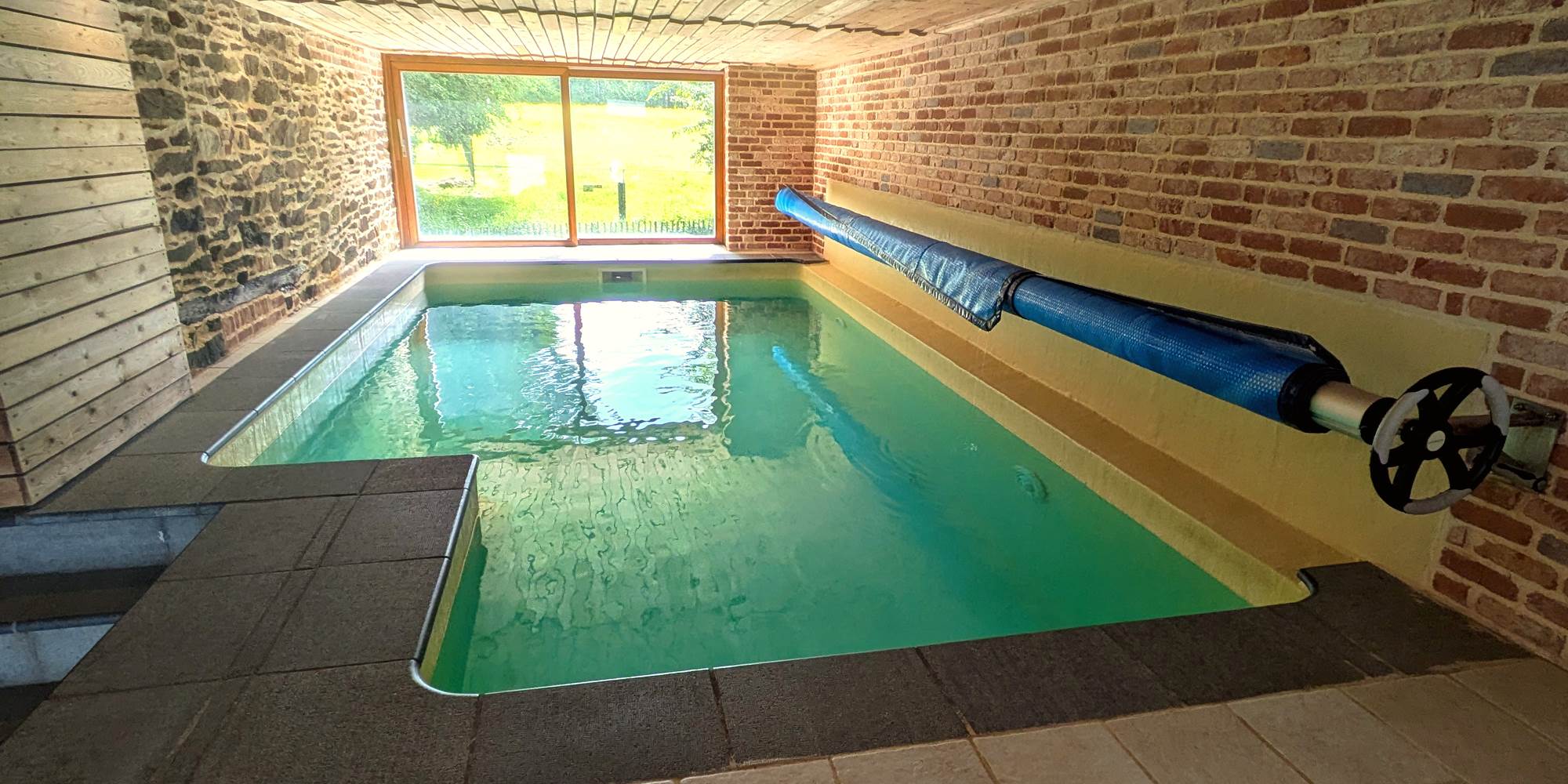 Indoor swimming pool with panoramic view over horse fields and countryside