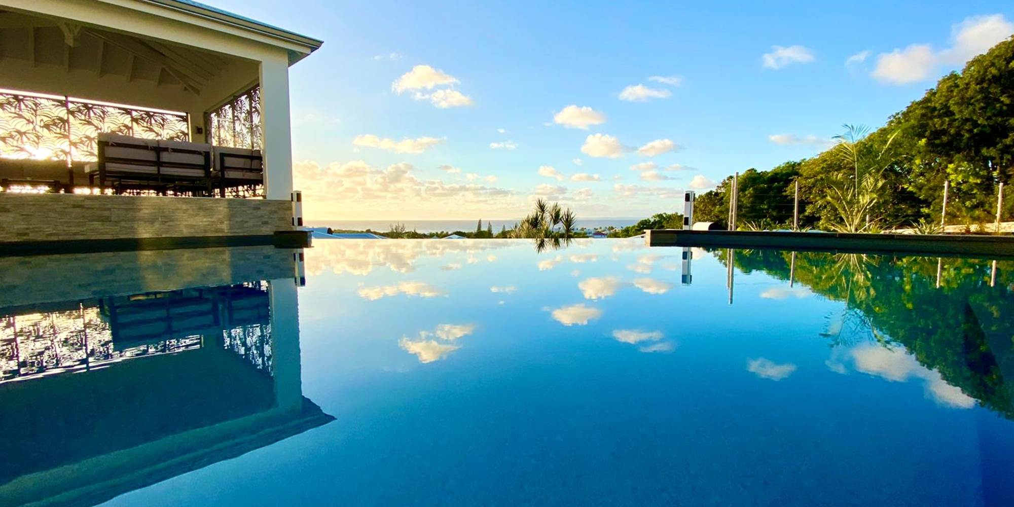 Piscine à débordement vue mer avec coin salon sous le carbet