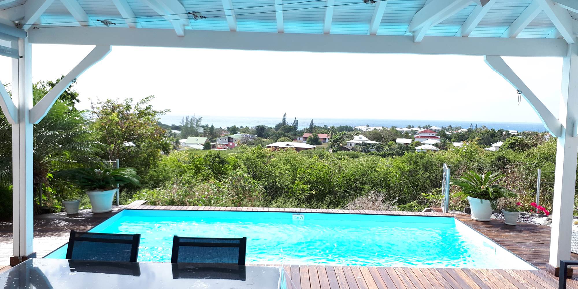 Terrasse couverte ouverte sur la piscine vue mer
