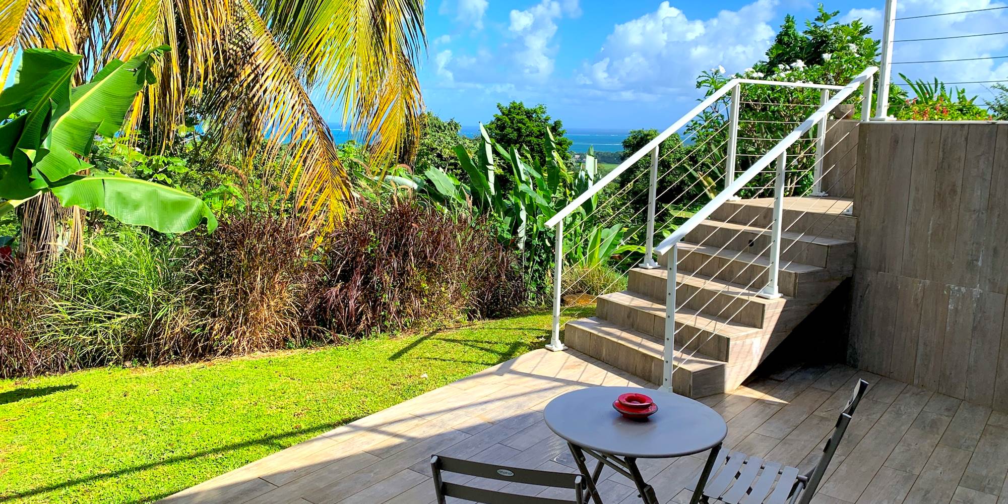 Terrasse privative avec vue mer et accès piscine par escalier