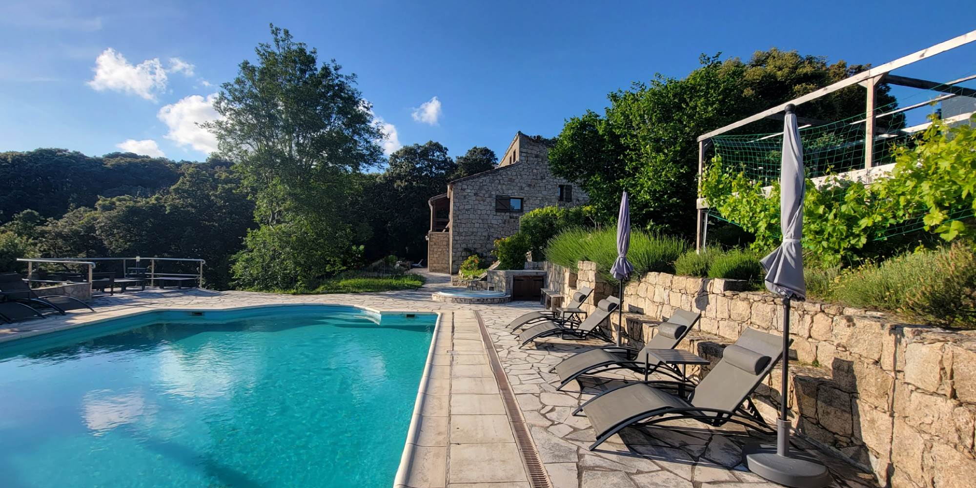 Espace détente avec transats modernes au bord de la piscine avec vue sur les montagnes.