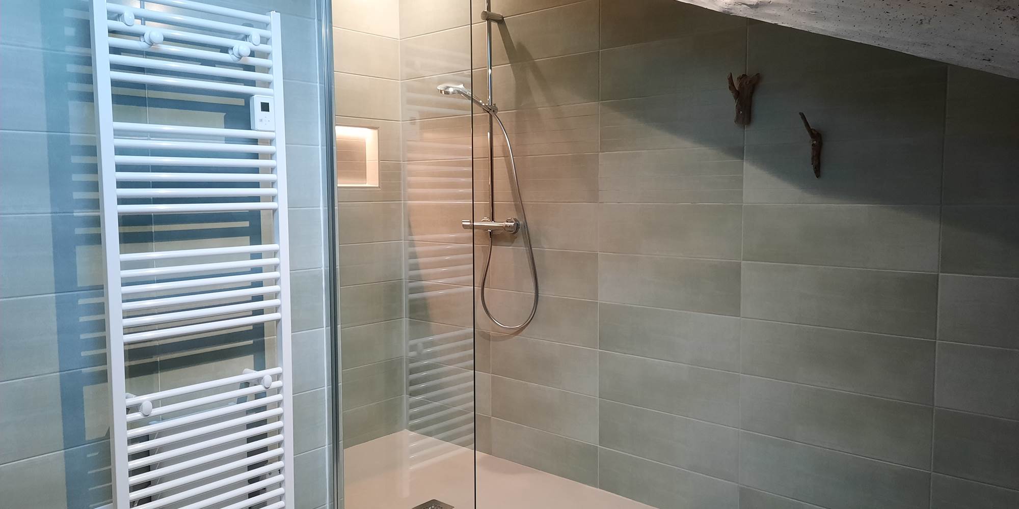 Une grande salle d'eau avec une douche à l'talienne d'1,6m et sa niche éclairée.