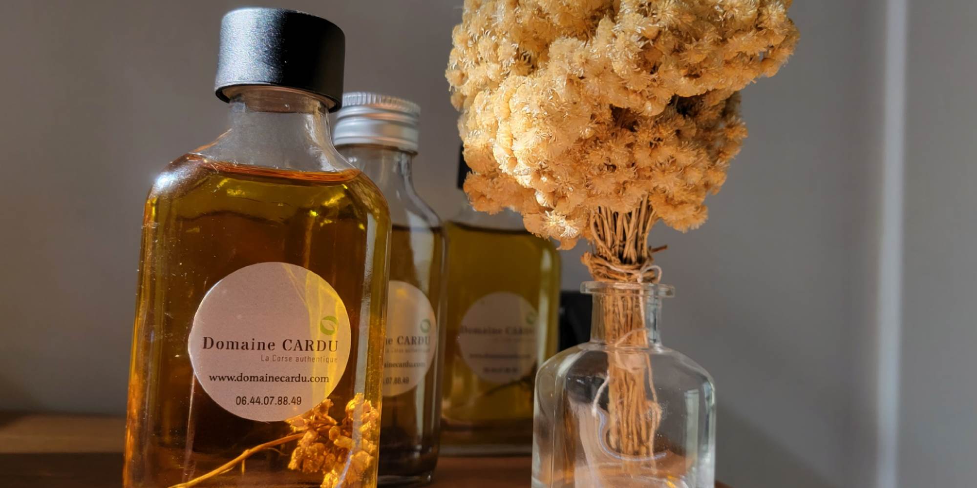 Produits artisanaux locaux : huile d'immortelle et fleurs séchées pour une immersion sensorielle.