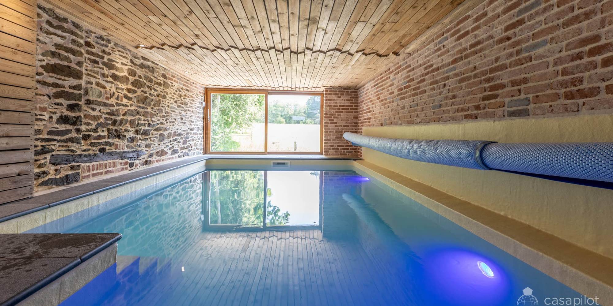 alt="Piscine intérieure chauffée du grand gîte familial en Ardenne belge pour séjours en groupe et vacances en famille"
