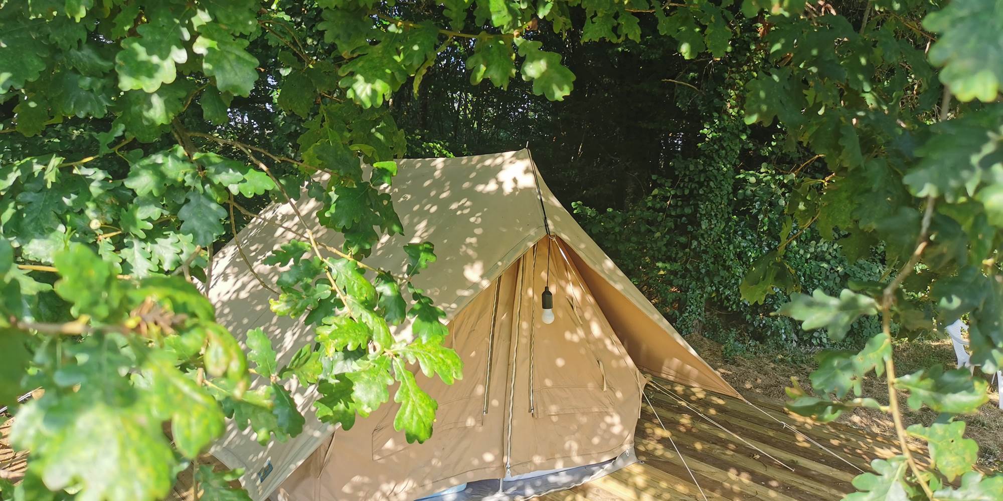 Tente en toile de coton installée sur une plateforme en bois