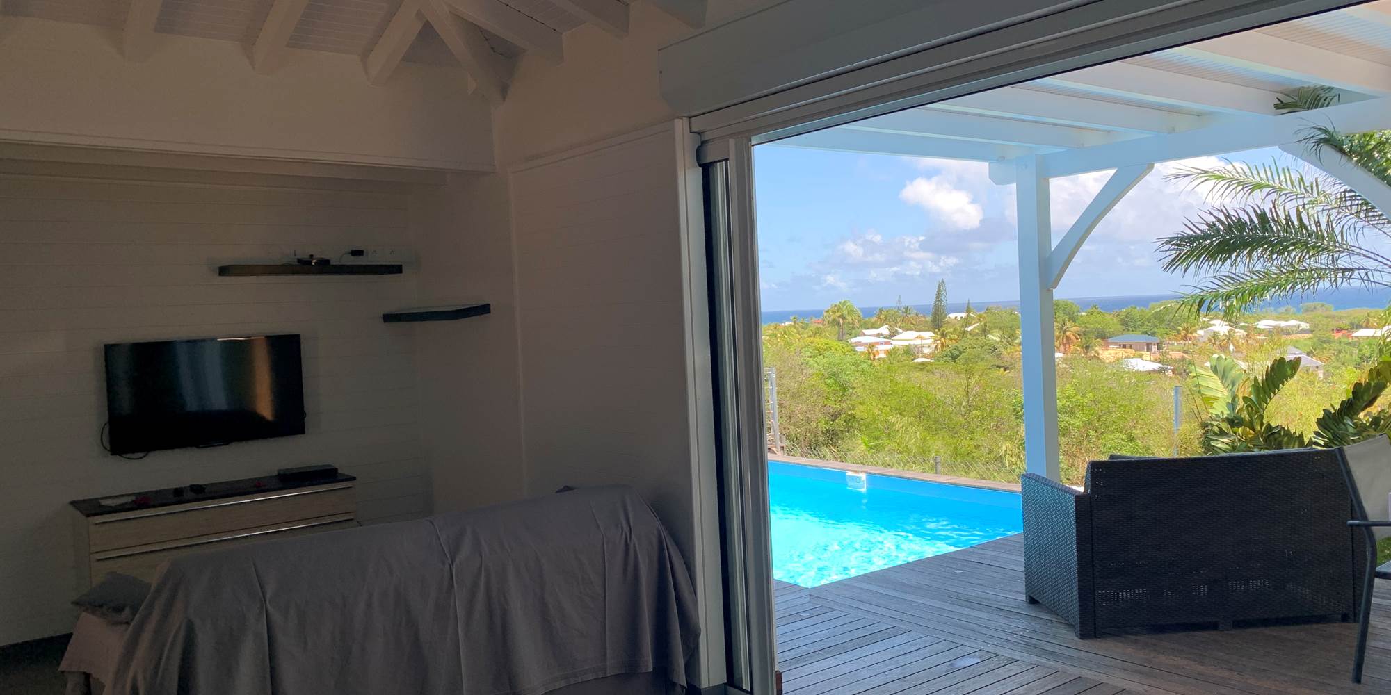 Salon ouvert sur la cuisine et la terrasse extérieure