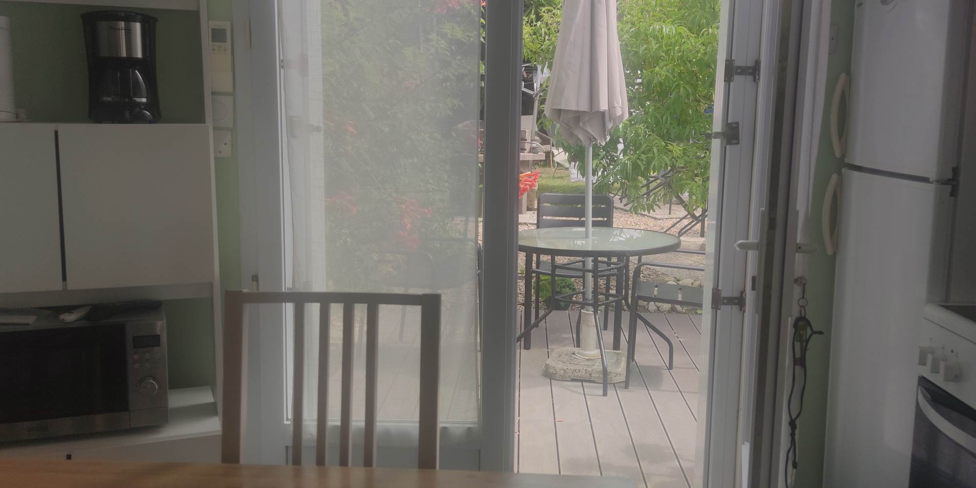 Table avec vue sur la terrasse Une transition naturelle entre l’intérieur et l’extérieur pour savourer chaque instant dans un cadre serein.